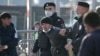 Police officers detain a foreign citizen outside Moscow's Multifunctional migration center.